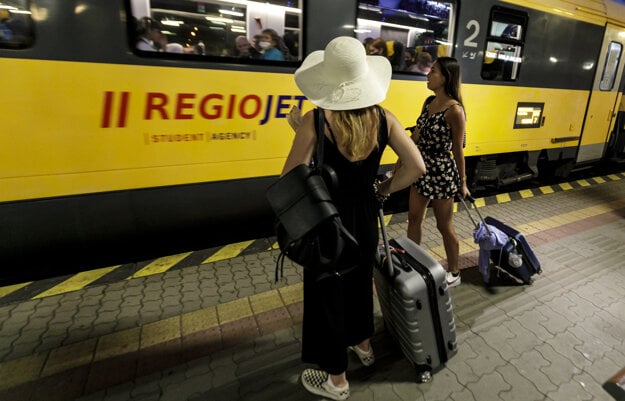 Holidaymakers in Bratislava get on a train from Prague, heading for Croatia, on June 30.