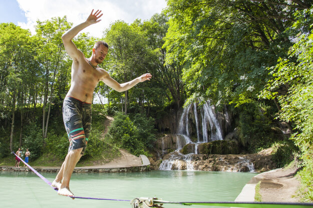 A man walks a tightrope over the Lúčky Waterfall.