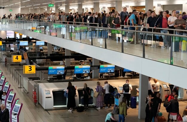 Passengers wait in long lines to check in and board flights at Amsterdam's Schiphol Airport, Netherlands, on June 21, 2022.