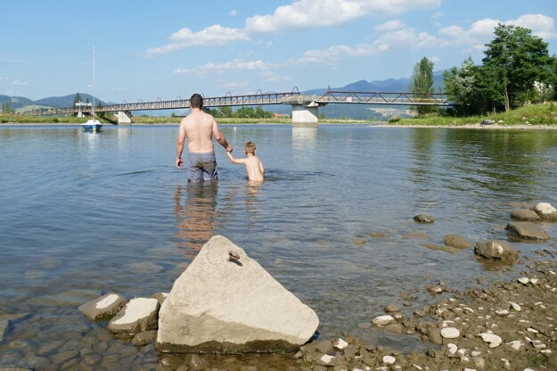 Ľudia si užívajú horúci deň na vodnej priehrade Jilina.