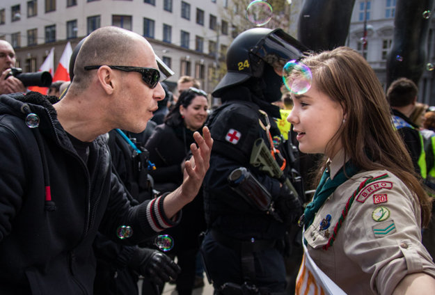 The photograph of Girl Scout Lucie Myslíková, aged 16, confronting an extremist was taken in the Czech city of Brno, during the May 1 protest called Those Who Play Do Not Salute the Nazi Way. The participants tried to block a neo-Nazi march, in a light-hearted way.