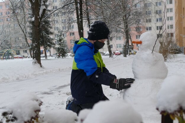 A boy builds a snowman in one of the boroughs in Žilina on January 13, 2021.