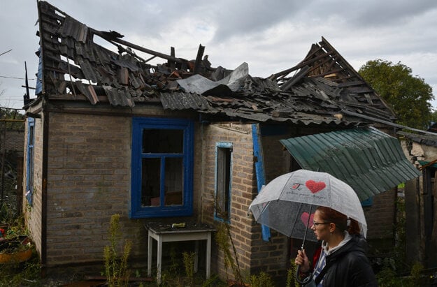 Local resident Ekaterina, 22, stands next to her residential building that was damaged after an overnight Russian attack in Kramatorsk, Ukraine, Tuesday, October 4, 2022.