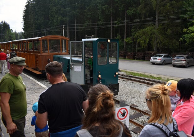 Conductor Jozef Ferenčík checks visitors' tickets before they get on the forest train.