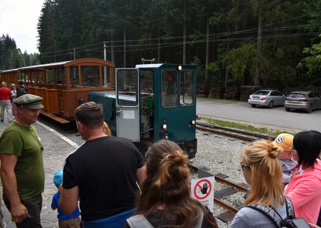 Conductor Jozef Ferenčík checks visitors' tickets before they get on the forest train. 