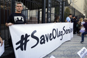 People hold posters to support Ukrainian filmmaker Oleg Sentsov, who is currently on hunger strike in a Russian jail to demand the release of the other Ukrainian hostages taken by the Kremlin, in front of the Embassy of the Russian Federation in Kiev on August 21, 2018.
