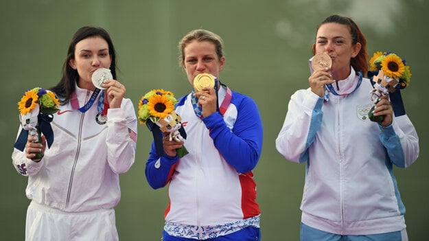 Slovak sports shooter Zuzana Rehák Štefečeková (centre) wins a gold medal in Tokyo.