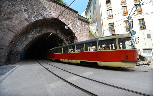 A tram enters a tunnel underneath Bratislava Castle.