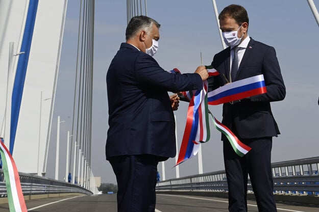 Hungarian PM Viktor Orban (left) and Slovak PM Igor Matovič exchange the ribbons they've just cut during the inauguration ceremony of a new bridge across the Danube River connecting the two countries in Komárom, Hungary.