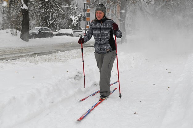 A woman is cross-country skiing on a sidewalk during a snowfall in Prešov on February 11, 2021.