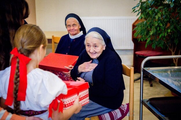 Older people receive Christmas presents from children.