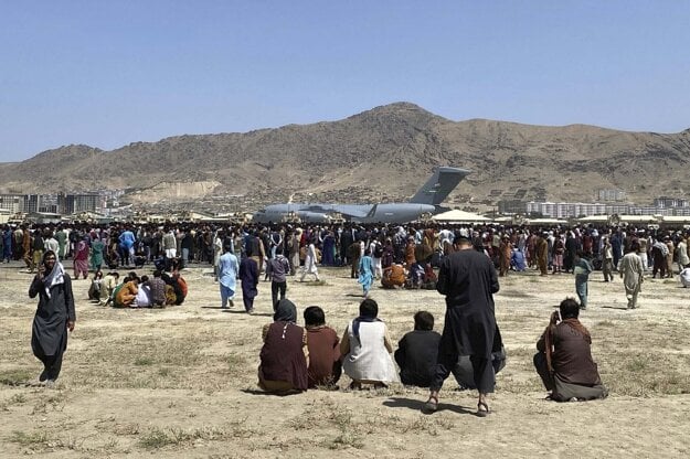 In this photo, taken on Aug. 16, 2021, hundreds of people gather near a U.S. Air Force C-17 transport plane along the perimeter at the international airport in Kabul, Afghanistan.